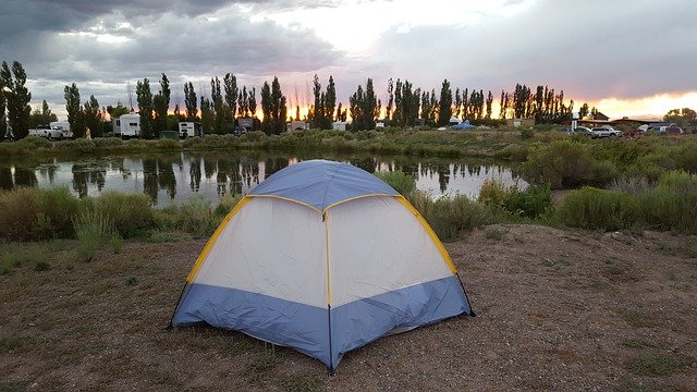 camping near a lake using a dome type camping tent